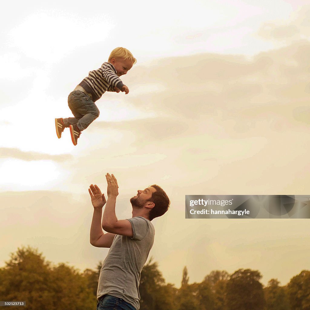 Father throwing son into air