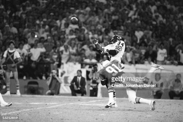 Walter Payton of the Chicago Bears throws a pass under pressure from Mack Moore of the Miami Dolphins during the game at the Orange Bowl on December...