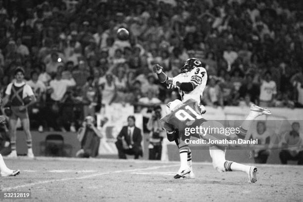 Walter Payton of the Chicago Bears throws a pass under pressure from Mack Moore of the Miami Dolphins during the game at the Orange Bowl on December...