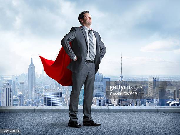 superhero businessman with cityscape in the background - business hero stock pictures, royalty-free photos & images