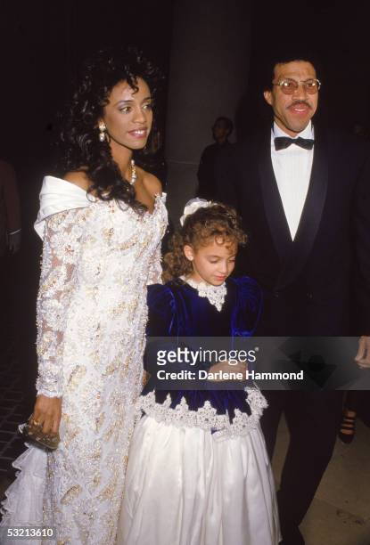 American R&B singer Lionel Richie arrives at a formal event with his wife Brenda and their daughter Nicole, late 1980s.
