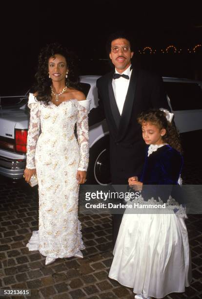 American R&B singer Lionel Richie arrives at a formal event with his wife Brenda and their daughter Nicole, late 1980s.