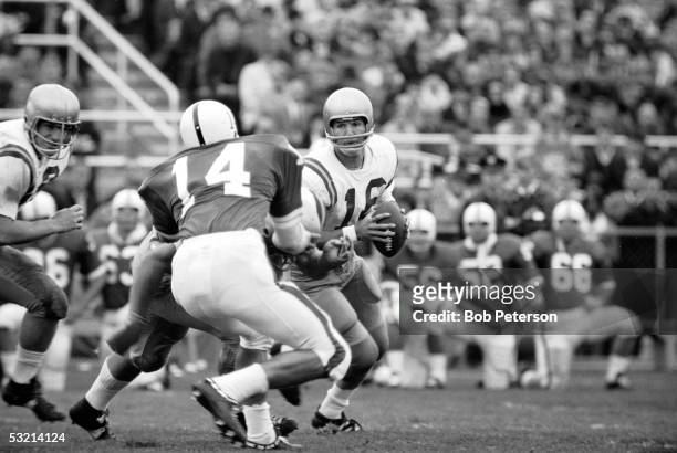 American college football player Gary Beban , quarterback for UCLA, scrambles with the ball for an opening during game against University of...