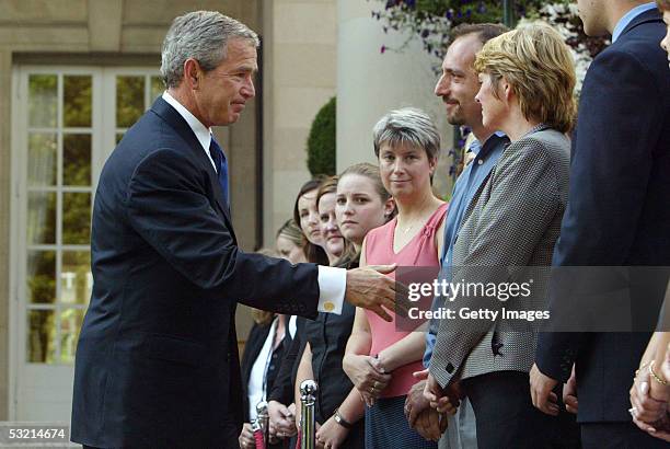 President George W. Bush shakes hands with people at the British Embassy after he laid a wreath in memory of those killed and injured during the...