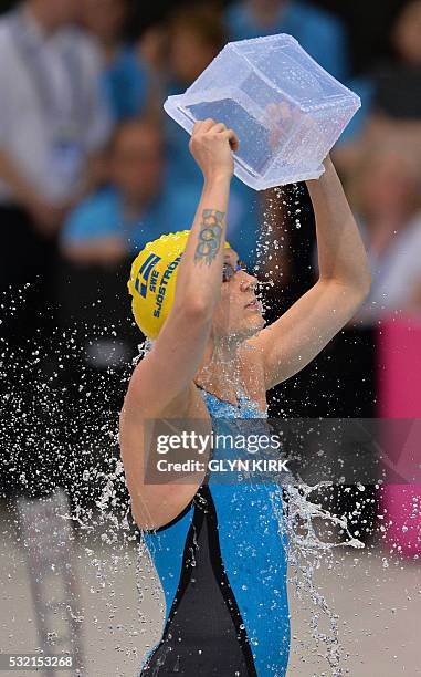 Sweden's Sarah Sjoestroem pours water over herself before competing in the final of the women's 100m Freestyle swimming event on Day 10 of the...