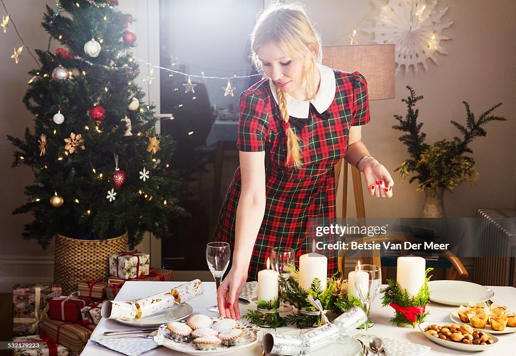 Woman preparing table with food for Christmas.