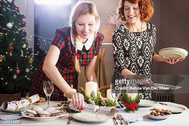 women preparing christmas dinner table. - holiday table stock pictures, royalty-free photos & images