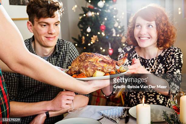 woman takes plate with turkey at christmas dinner. - cooked turkey white plate stockfoto's en -beelden
