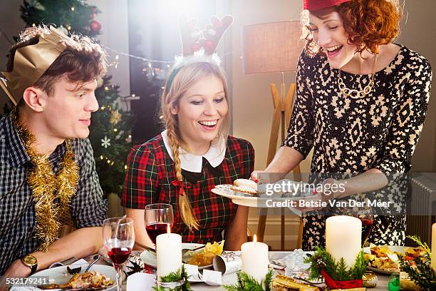 woman presenting mince pies at christmas dinner. - man eating pie stock pictures, royalty-free photos & images