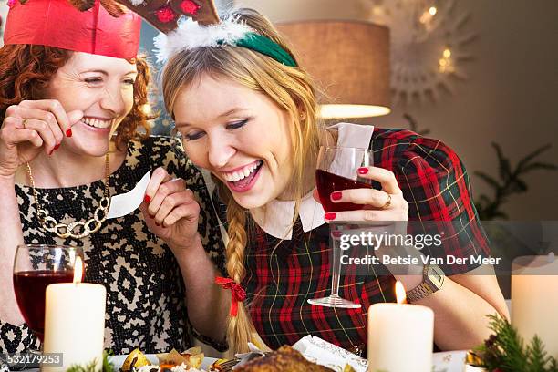 friends laughing at joke at christmas dinner table - christmas wine stock pictures, royalty-free photos & images