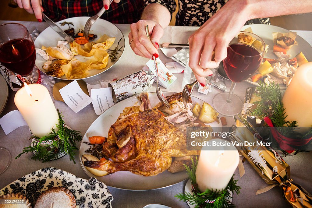 Close up of hands taking turkey and cutting food.