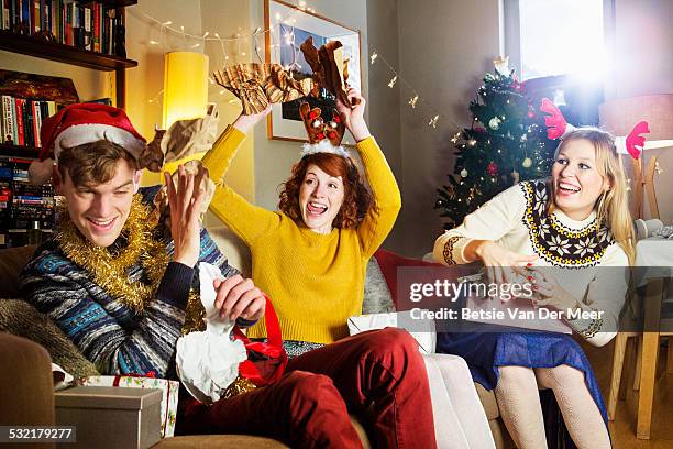 friends play fighting while unpacking presents. - christmas fun stock pictures, royalty-free photos & images