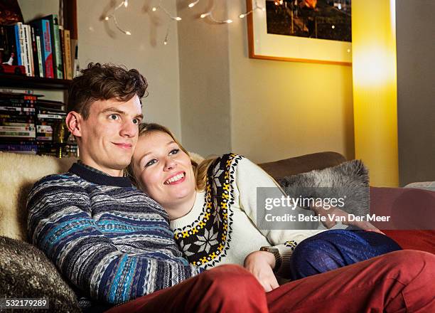 couple watching tv at home. - couple on sofa stock pictures, royalty-free photos & images