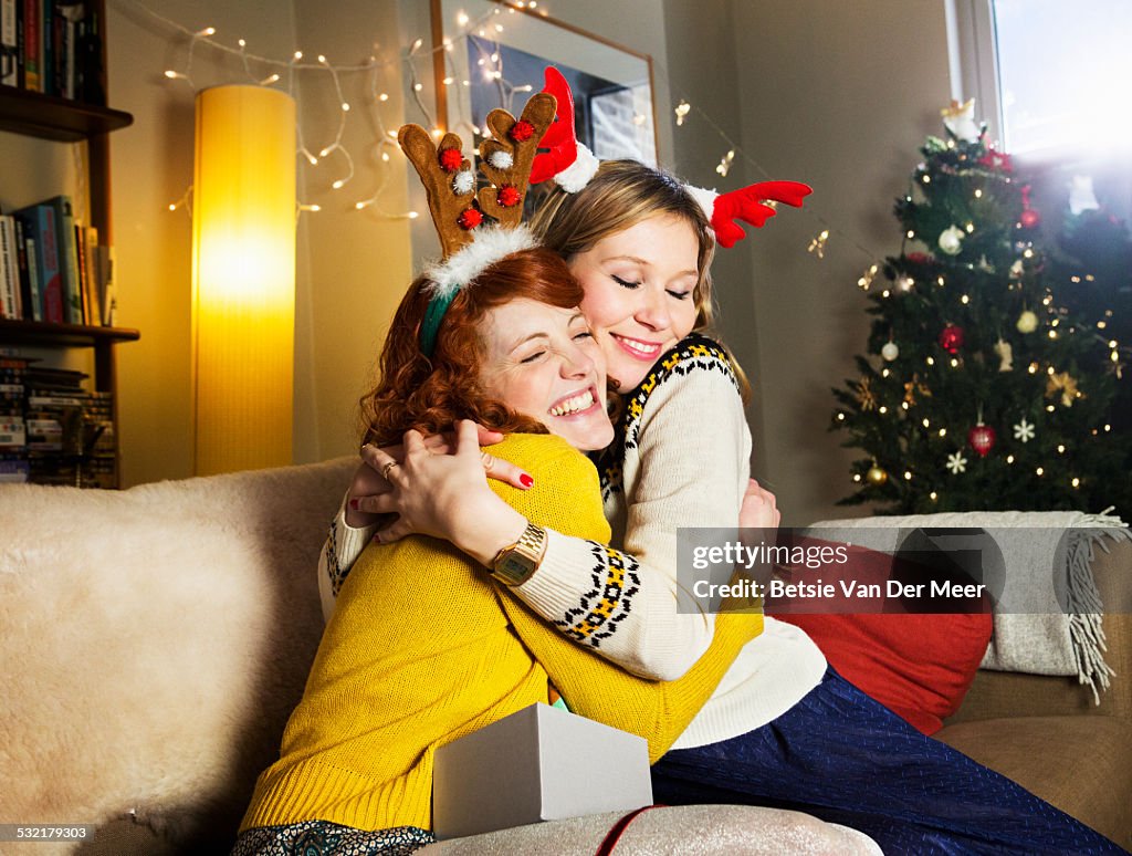 Female friends embrace at Christmas.