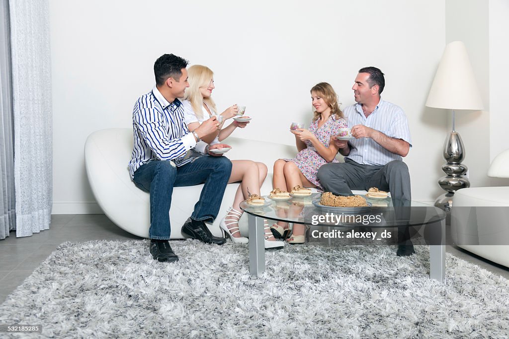 Two couples at teaparty in livingroom