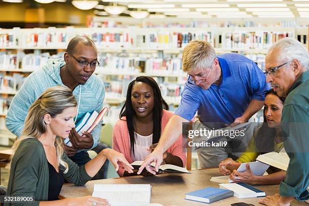 estudiantes adultos estudiando juntos en una biblioteca - teacher meeting fotografías e imágenes de stock