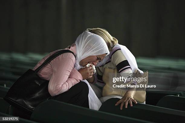Relatives of some of the Srebrenica massacre victims cry in front of the 610 coffins containing the remains of their family members at the Srebrenica...