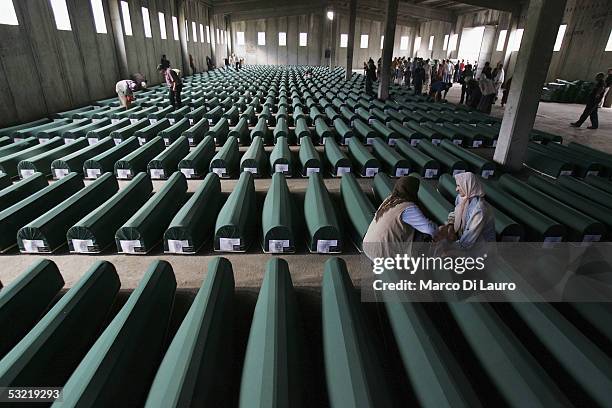 Relatives of some of the Srebrenica massacre victims pray in front of the 610 coffins containing the remains of their family members at the...