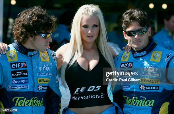 Fernando Alonso of Spain and Renault and Giancarlo Fisichella of Italy and Renault pose with model Michelle Marsh to promote Michelle Marsh and model...