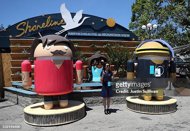 An attendee poses for a photo next to Android characters during Google I/O 2016 at Shoreline Amphitheatre on May 19, 2016 in Mountain View,...