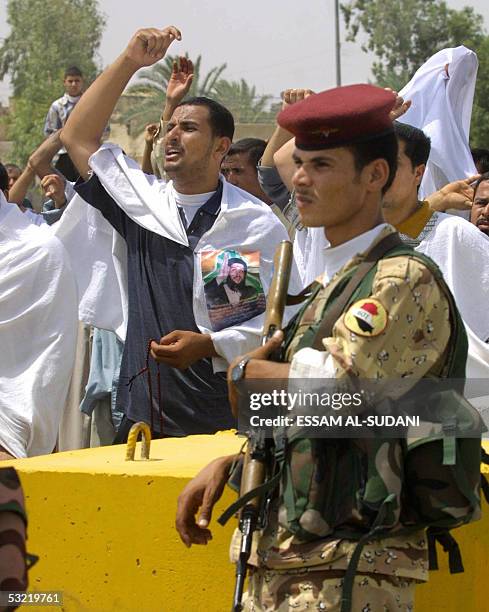 Iraqis demonstrate outside the heavily guarded Iraqi authority building in the Iraqi southern city of Basra, 10 July 2005 to protest against an...