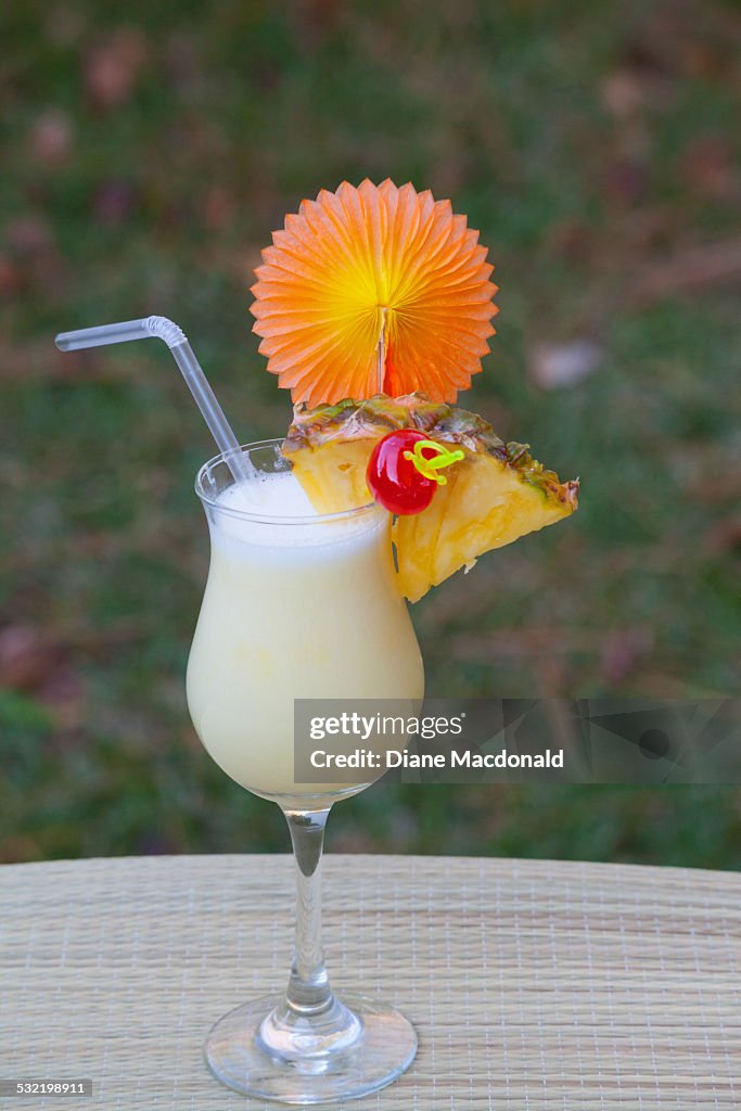 Pina colada outdoors with pineapple and cherry