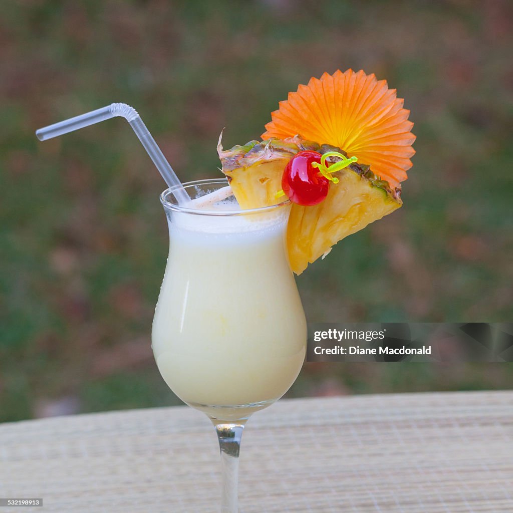 Pina colada outdoors with pineapple and cherry