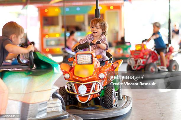 ttwo children who play bumper cars - autoscooter stock-fotos und bilder