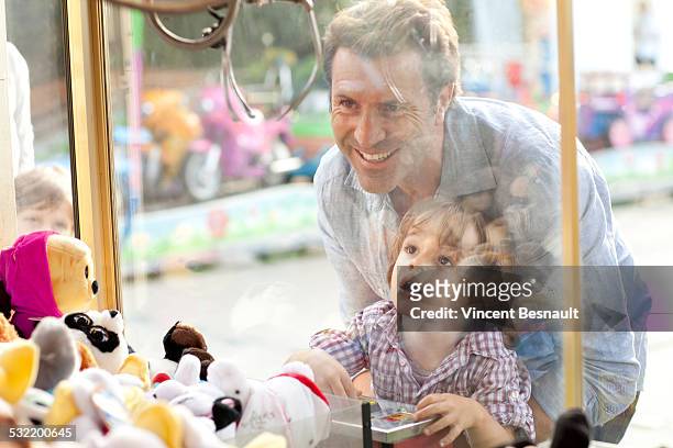 father and son at the carnival - claw machine stock pictures, royalty-free photos & images
