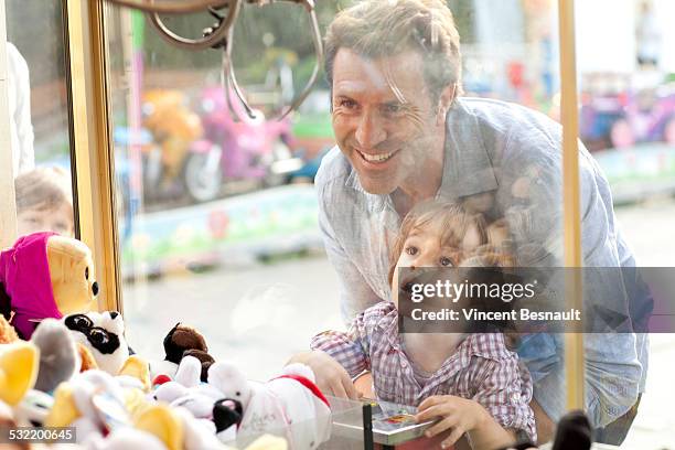 father and son at the carnival - claw machine bildbanksfoton och bilder