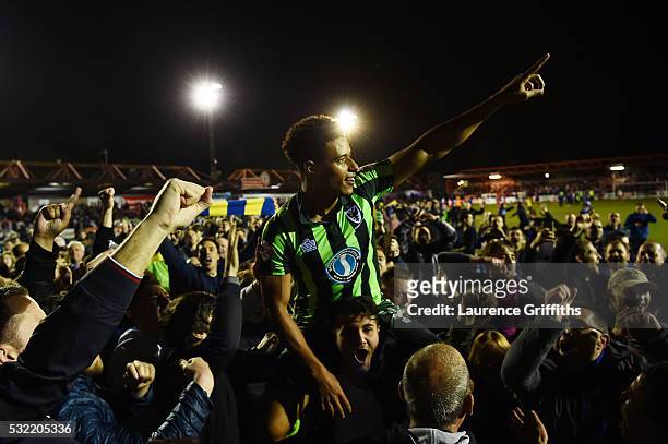 Tie winning goalscorer Lyle Taylor of AFC Wimbledon is carried aloft by the fans after their team wins promotion to League One during the Sky Bet...