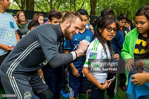 Seattle Sounders FC goalkeeper Stefan Frei with a local art student from Voyager Middle School at "The Fabric of Sounders FC" design project uniting...