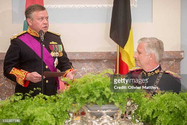 King Abdullah II of Jordan delivers a speech as King Philippe of Belgium looks on during the gala dinner at the Royal Palace of Lakaen on May 18,...