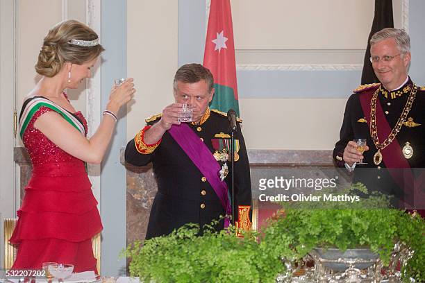 Queen Mathilde of Belgium, King Abdullah II of Jordan and King Philippe of Belgium drink a toast during the gala dinner at the Royal Palace of Lakaen...