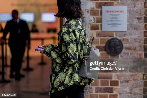 Guest wearing a jacket with floral print and backpack outside Yuxin at Mercedes-Benz Fashion Week Resort 17 Collections at Carriageworks on May 18,...