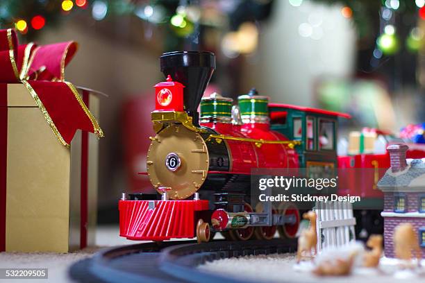 christmas train under tree with wrapped gifts - model train stock pictures, royalty-free photos & images