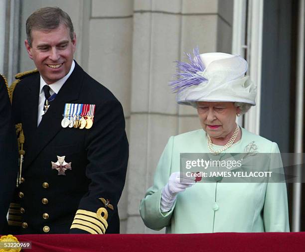 Queen Elizath II hold a poppy dropped from a Lancaster bombe as she stands next to Prince Andrew on the balcony of Buckingham Palace during the...