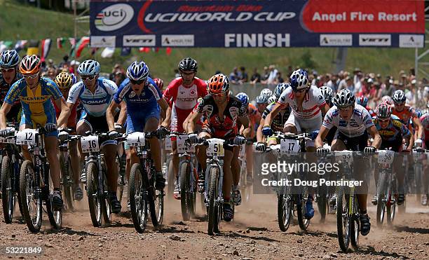 Competitors leave the start in the Men's Cross Country Race at the UCI Mountain Bike World Cup at the Angel Fire Resort on July 10, 2005 in Angel...
