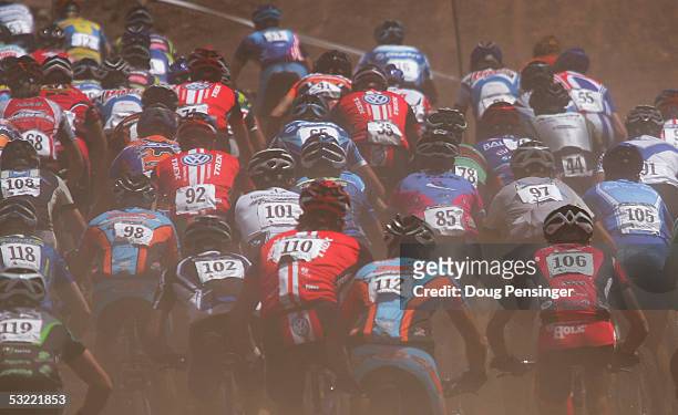 Competitors enter the course in a cloud of dust during the Men's Cross Country Race at the UCI Mountain Bike World Cup at the Angel Fire Resort on...