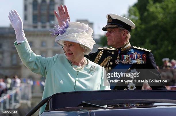 Queen Elizabeth II, The Queen, and Prince Philip, the Duke of Edinburgh, wave to the crowd as they leave the "Recollections Of World War II...
