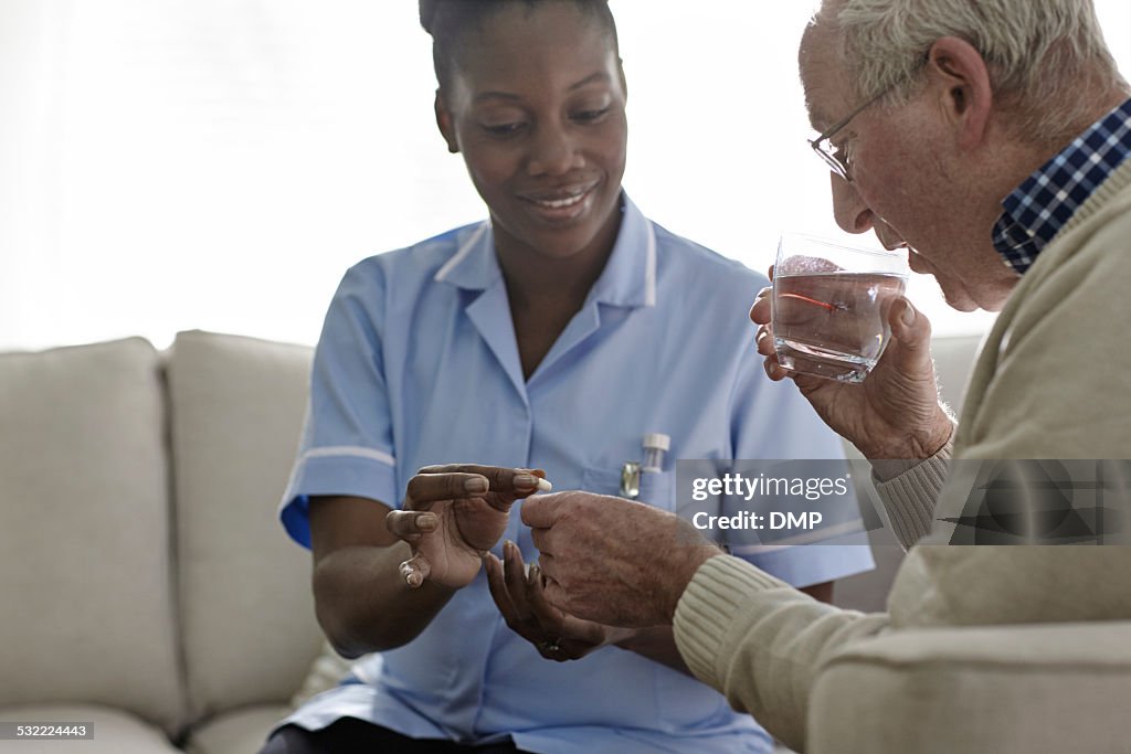 Femmina medico dando farmaco per paziente anziano