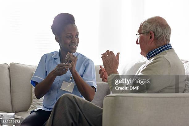 weibliche theropist die durchführung rhythmischen sitzung mit einem älteren mannes. - communication nurse stock-fotos und bilder