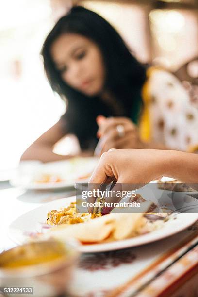 indian woman eating with hands in restaurant - munchies stock pictures, royalty-free photos & images