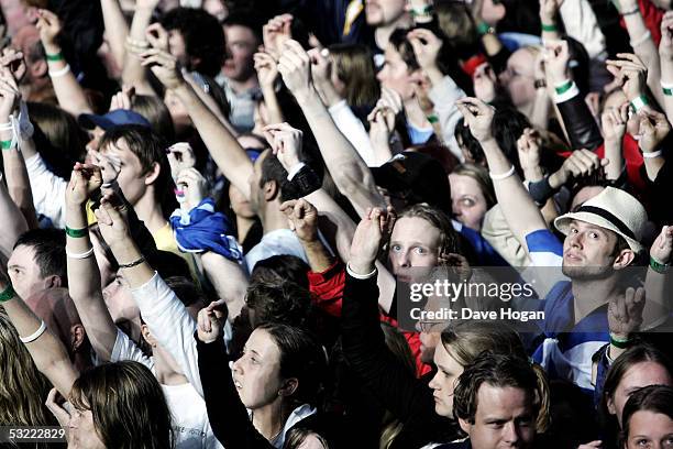 The crowd click their fingers to represent the frequency of African infant mortality at the Live 8 Edinburgh concert at Murrayfield Stadium on July...