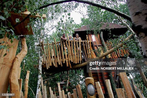 File picture taken on 25 June 2005 shows guests of Germany's first tree house hotel in Zentendorf, eastern Germany, standing in front of their tree...