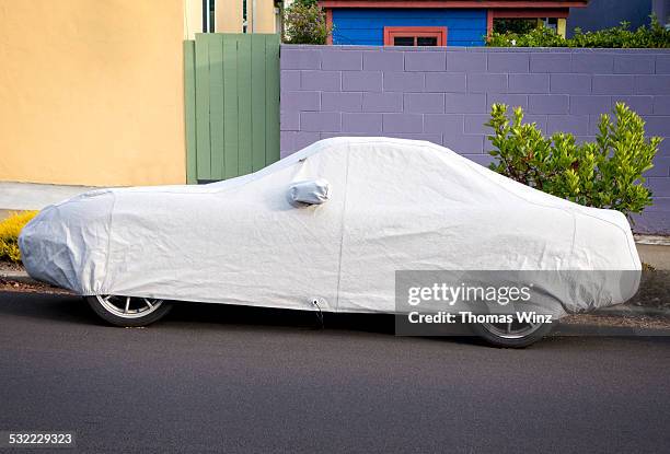 covered car parked on street - covered car street stock pictures, royalty-free photos & images