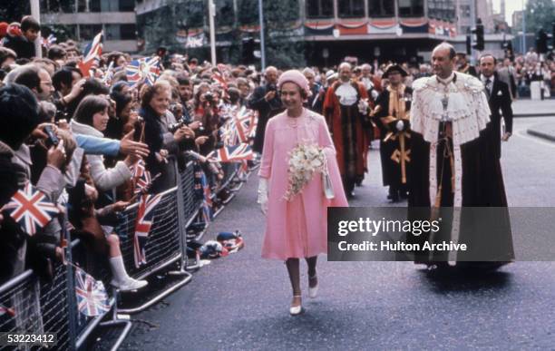 Queen Elizabeth II is greeted by crowds in London during celebrations of her Silver Jubilee, 7th June 1977. She is accompanied by the Lord Mayor of...