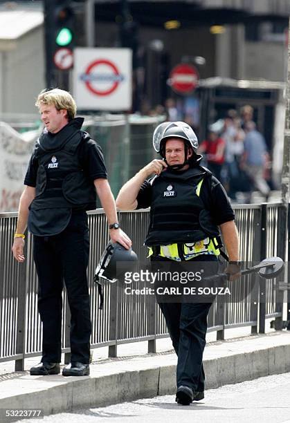London, UNITED KINGDOM: Police bomb squad experts return to their vehicle after a bag sparked a bomb scare at Kings Cross train station 11 July 2005....