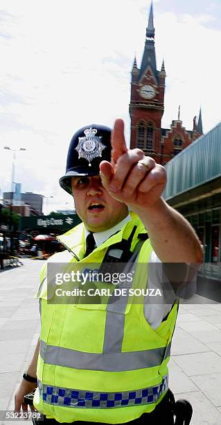 London, UNITED KINGDOM: A police officer urges the public to move back after a bag sparked a bomb scare at Kings Cross train station, in London,11...