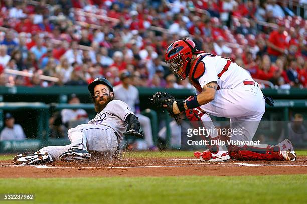 Charlie Blackmon of the Colorado Rockies is tagged out at home plate by Yadier Molina of the St. Louis Cardinals in the first inning at Busch Stadium...